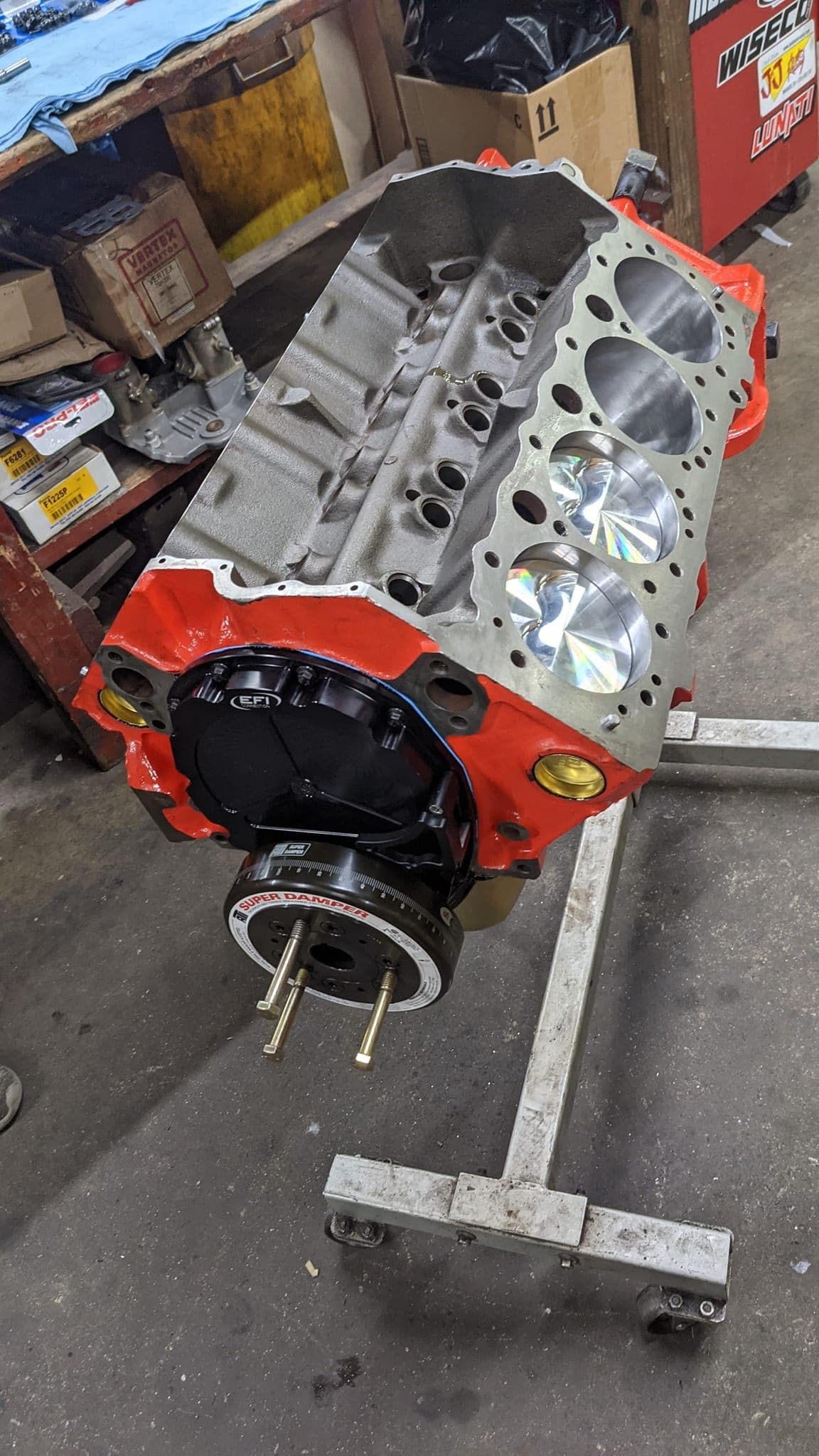 Freshly assembled small-block Chevy short block on an engine stand, bare block with new aluminum cylinder heads installed and no intake yet