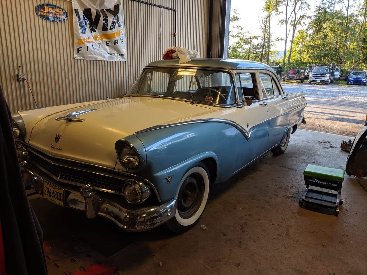 1955 Ford Fairlane freshly repainted in Stratocaster blue and white, parked in the NextGen AutoWorks shop bay