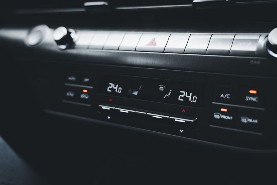 Close-up shot of a car's climate control system displaying temperature settings during an overheating concern.