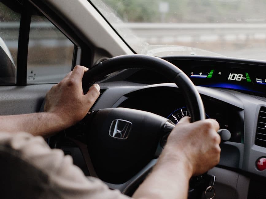 Driver view of steering wheel and dashboard while checking a car that pulls to one side.