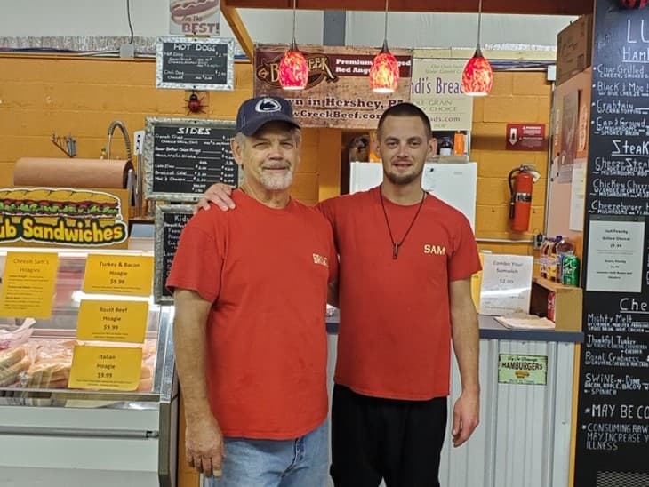 Dave and Sam behind the counter at Cheezie Sam's Grill inside Farmstead Farmers Market