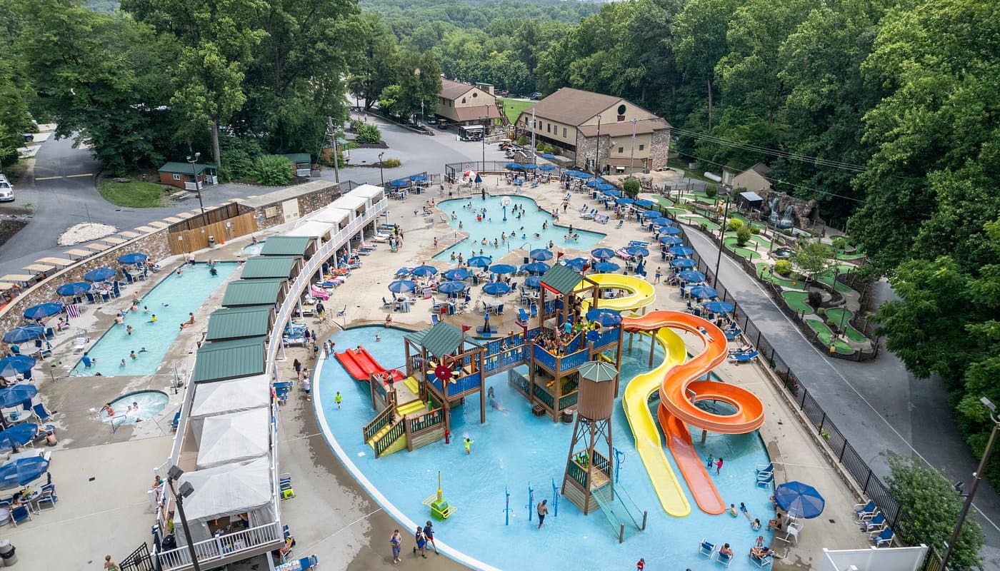 Aerial view of the water-play complex at Yogi Bear's Jellystone Park in Quarryville, PA, with pools, water slides, a splash playground, and mini golf