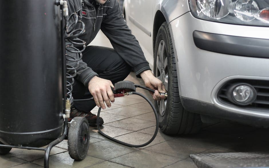 Mechanic inspecting uneven tire wear and tire pressure in an auto repair shop.